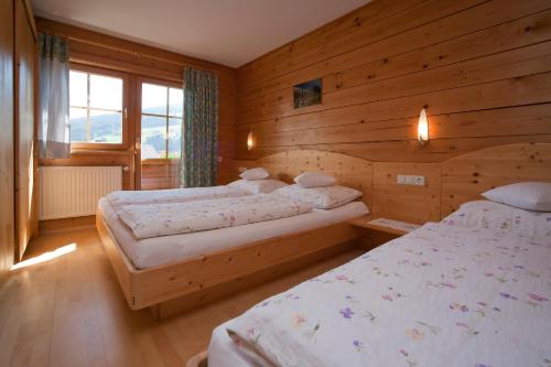 1 dormitorio con 2 camas en una cabaña de madera en Abelhof, en Schladming