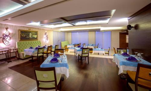 a dining room with tables and chairs with blue dishes on them at Porto Bello Hotel Resort & Spa in Antalya