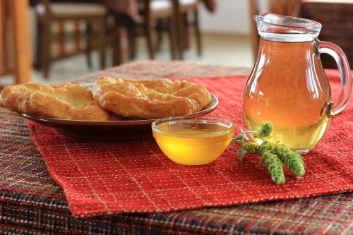 una mesa con un plato de pan y un tarro de miel en Hotel Mursal, en Yagodina