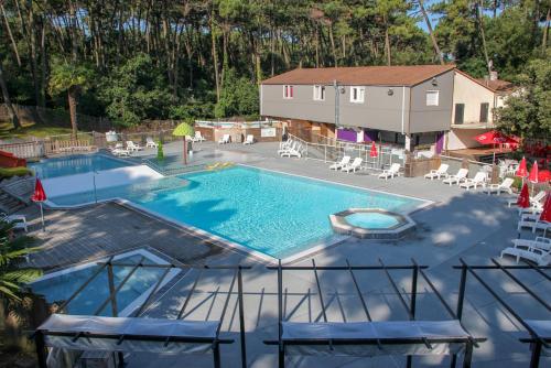 an overhead view of a swimming pool with chairs and a house at Océan Vacances - Camping Paradis in Saint-Georges-de-Didonne