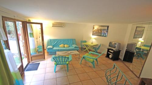 un salon avec un canapé bleu et des chaises dans l'établissement Le Bateau, à Sainte-Maxime