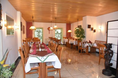 Hotel Harsshof في زالتسغيتر: غرفة طعام مع طاولات وكراسي في مطعم