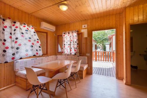 a dining room with a table and chairs at Camping Los Llanos in Denia