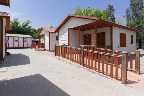a small house with a porch and a fence at Camping Los Llanos in Denia