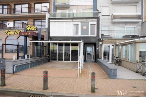 a building with a parking lot in front of it at Residentie Les Algues 8ste verdieping in Blankenberge