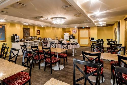 a restaurant with tables and chairs and a bar at Meriton Old Town Garden Hotel in Tallinn