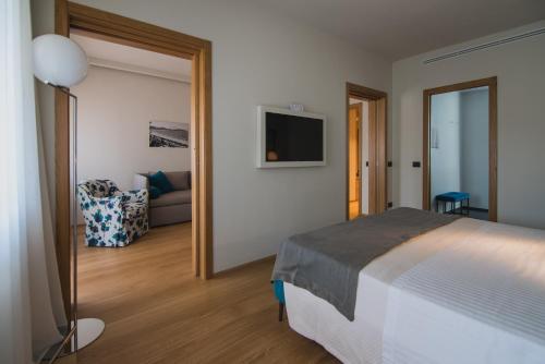a bedroom with a bed and a living room at Gallia Palace Hotel - Relais & Châteaux in Punta Ala