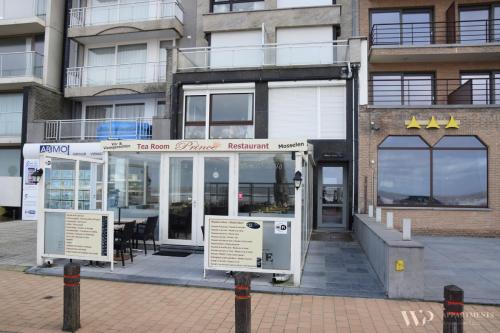 a restaurant in front of a building with windows at Appartement Lucia, 8ste verdieping in Blankenberge