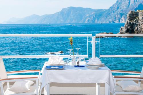 a table and chairs on a boat in the ocean at Grand Hotel Tritone in Praiano