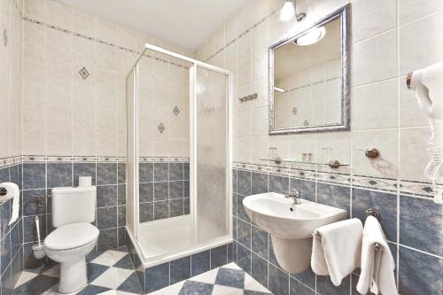 a bathroom with a toilet and a sink and a shower at Attic Hotel in Prague