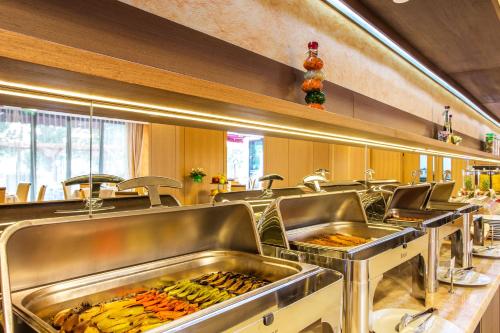 a kitchen with a bunch of trays of food at Landmark Creek Hotel Plovdiv in Plovdiv