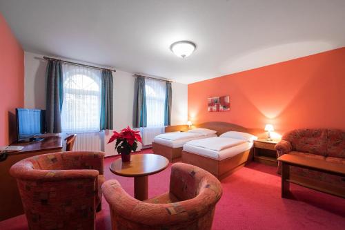 a hotel room with a bed and a table and chairs at Attic Hotel in Prague