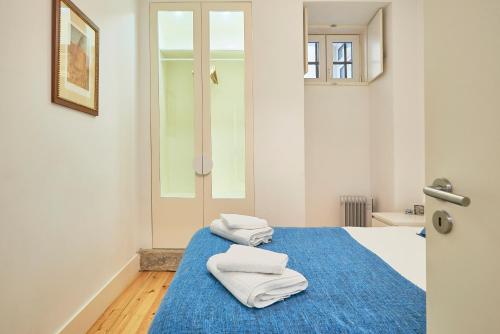 a bedroom with two white towels on a blue bed at Casa Eclea Lisbon Principe Real in Lisbon