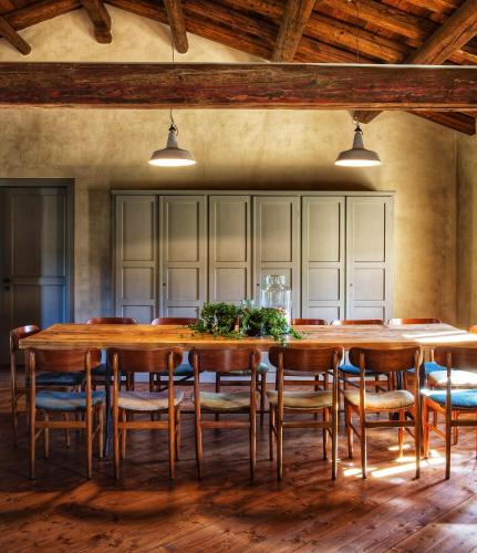 a dining room with a large wooden table and chairs at Foresteria San Rocco Borgoluce in Susegana