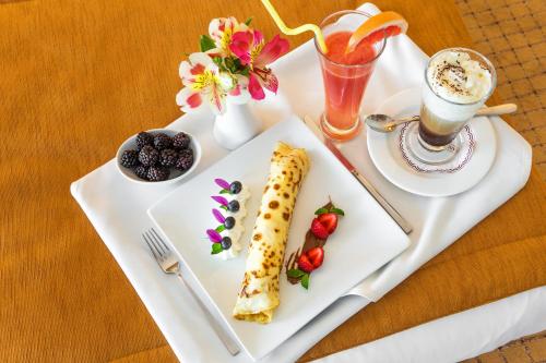 a white tray with a plate of food on a table at Landmark Creek Hotel Plovdiv in Plovdiv