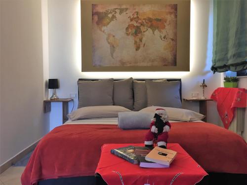 una cama con una manta roja y un animal de peluche sobre una mesa en Etna Hills sea, en Aci Trezza