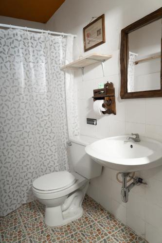 a bathroom with a white toilet and a sink at Past Tense Hostel in Chiang Mai