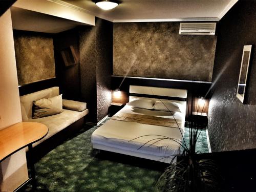 Discret Hotel & Restaurant في Vladaya: غرفة نوم بسرير واريكة