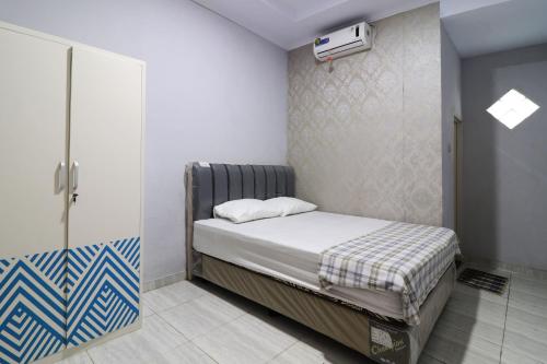 a small bedroom with a bed in a room at Ombey Guest House in Bogor