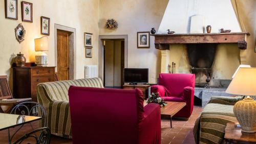 uma sala de estar com duas cadeiras e uma lareira em Tenuta di Ghizzano Resort em Ghizzano
