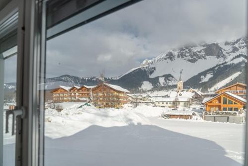 a view of a snow covered mountain from a window at Appartements Ramsau am Dachstein by Schladmingurlaub in Ramsau am Dachstein