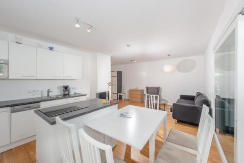 a kitchen and living room with a white table and chairs at Appartements Ramsau am Dachstein by Schladmingurlaub in Ramsau am Dachstein