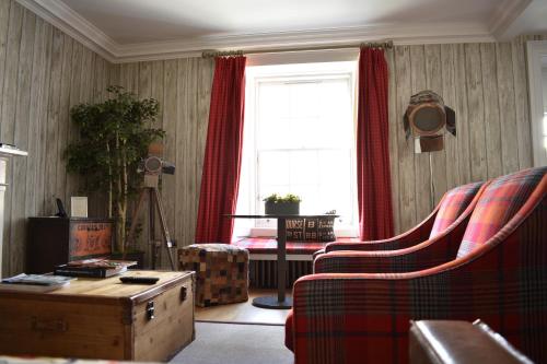 a living room with a couch and a window at The Rutland Hotel & Apartments in Edinburgh