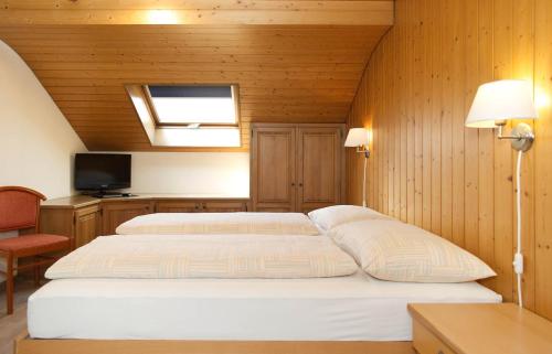 a bedroom with two beds in a room with wooden walls at Rössli Holiday Apartment in Interlaken