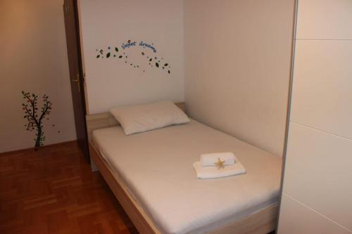 Cette petite chambre comprend un lit et une serviette. dans l'établissement Apartment Time out, à Kaštela