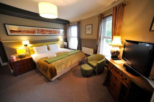 um quarto com uma cama e uma televisão de ecrã plano em The Pilot Inn em Eastbourne