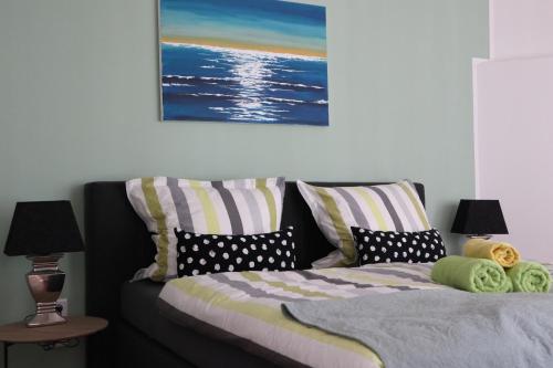 ein Schlafzimmer mit einem Bett mit Kissen und einem Gemälde in der Unterkunft galerie 65 in Nettetal
