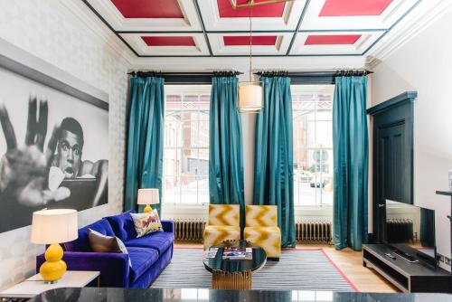 a living room with a purple couch and blue curtains at The Rutland Hotel & Apartments in Edinburgh