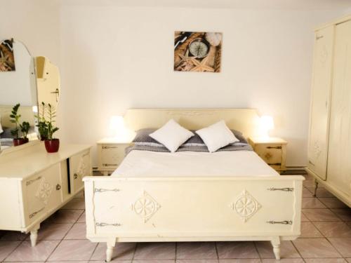 a bedroom with a white bed and two dressers at Apartment south in Darłowo