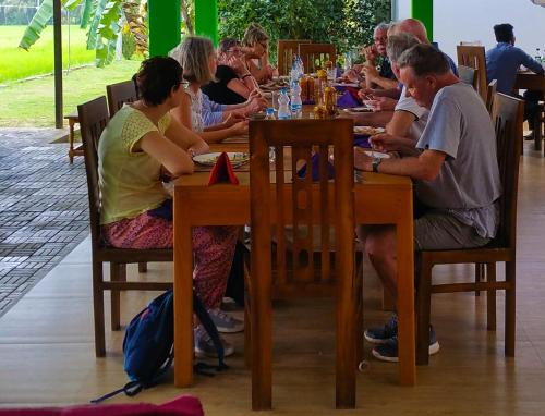 a group of people sitting at a table in a restaurant at Rivonway Hotel Polonnaruwa in Polonnaruwa