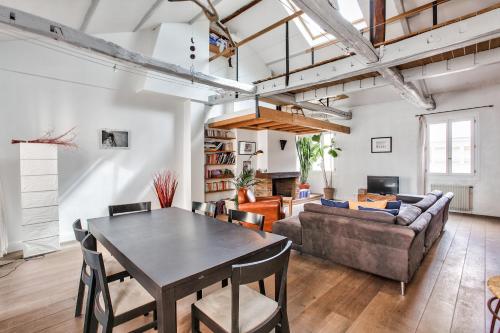 un salon avec une table et un canapé dans l'établissement Charming duplex Bastille by weekome, à Paris
