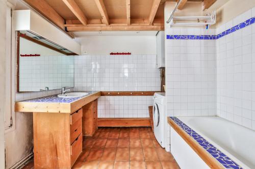 La salle de bains est pourvue d'une baignoire, d'un lavabo et d'un lave-linge. dans l'établissement Charming duplex Bastille by weekome, à Paris