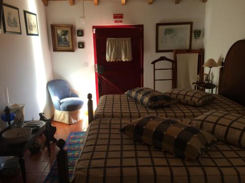 a bedroom with two beds and a blue chair at Quarto em Monte Alentejano perto do Cercal in Cercal