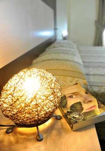 a lamp sitting on a table next to a book at Hotel Gabbiano in Mola di Bari