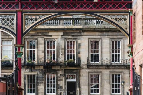 an old building with a balcony with flowers on it at The Rutland Hotel & Apartments in Edinburgh