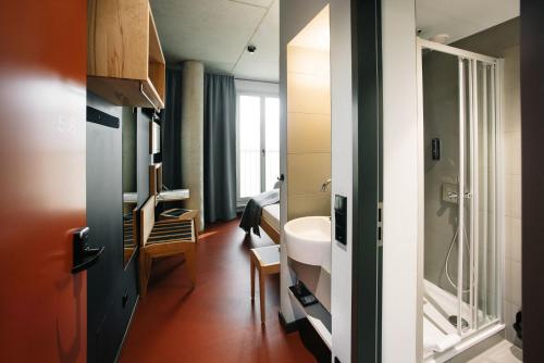 een badkamer met een wastafel en een spiegel bij Hotel Rossi in Berlijn