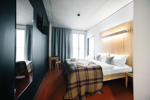 a hotel room with a bed and two windows at Hotel Rossi in Berlin