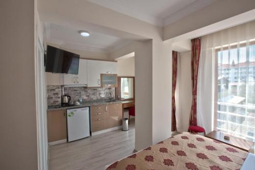 a room with a bed and a kitchen with a window at Bolu Cadde Otel in Bolu