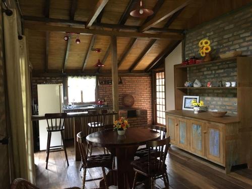 - une cuisine et une salle à manger avec une table et des chaises dans l'établissement Pousada Bergen Hütten, à Rio Fortuna