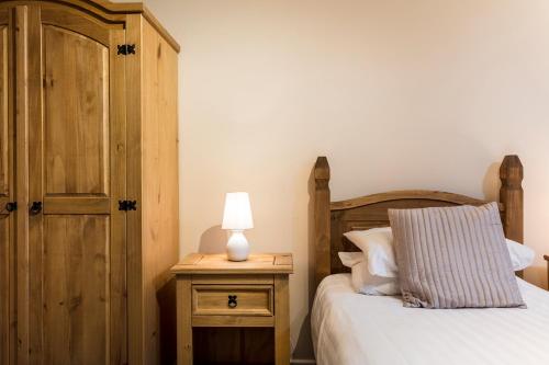 a bedroom with a bed and a lamp on a night stand at Roydon Marina Village Hotel in Roydon