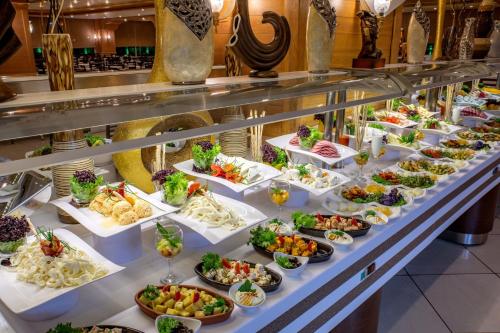 a buffet line with plates of food on display at Porto Bello Hotel Resort & Spa in Antalya
