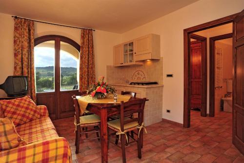 a living room with a table and a kitchen at Hotel La Fonte Del Cerro in Saturnia