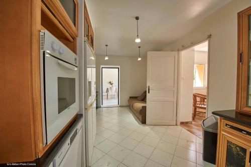 Il comprend un salon et une cuisine équipée de plaques de cuisson. dans l'établissement Maison L'Olivier avec piscine, à Cuttoli-Corticchiato