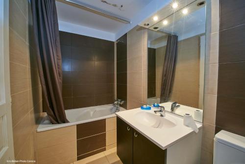 une salle de bain avec un lavabo et une baignoire dans l'établissement Maison L'Olivier avec piscine, à Cuttoli-Corticchiato