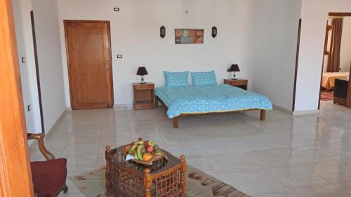 a living room with a bed and a bowl of fruit at Thebes Hotel in Luxor