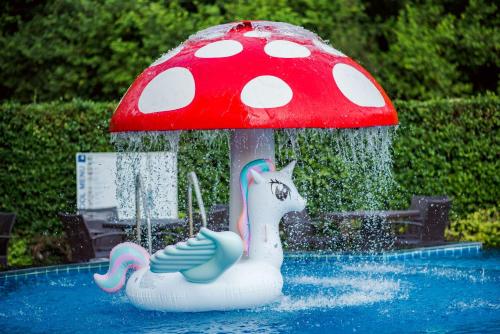 a red and white mushroom umbrella in a pool at Golden Beach Cha-Am Hotel in Cha Am